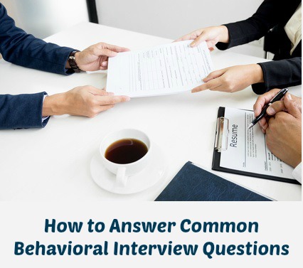 Hands passing resume across desk in behavioral interview situation